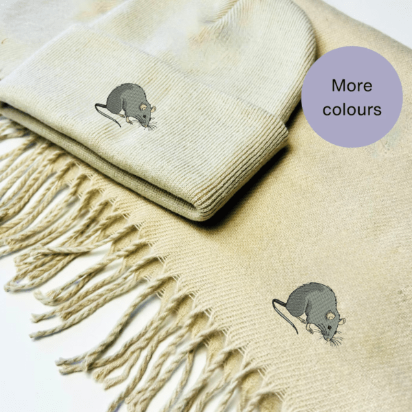 A cozy winter scarf and beanie hat set featuring an intricately embroidered rat design. Available in red, natural, navy blue, black, and grey, this unisex set is perfect for rat lovers and offers warmth and style for chilly days.